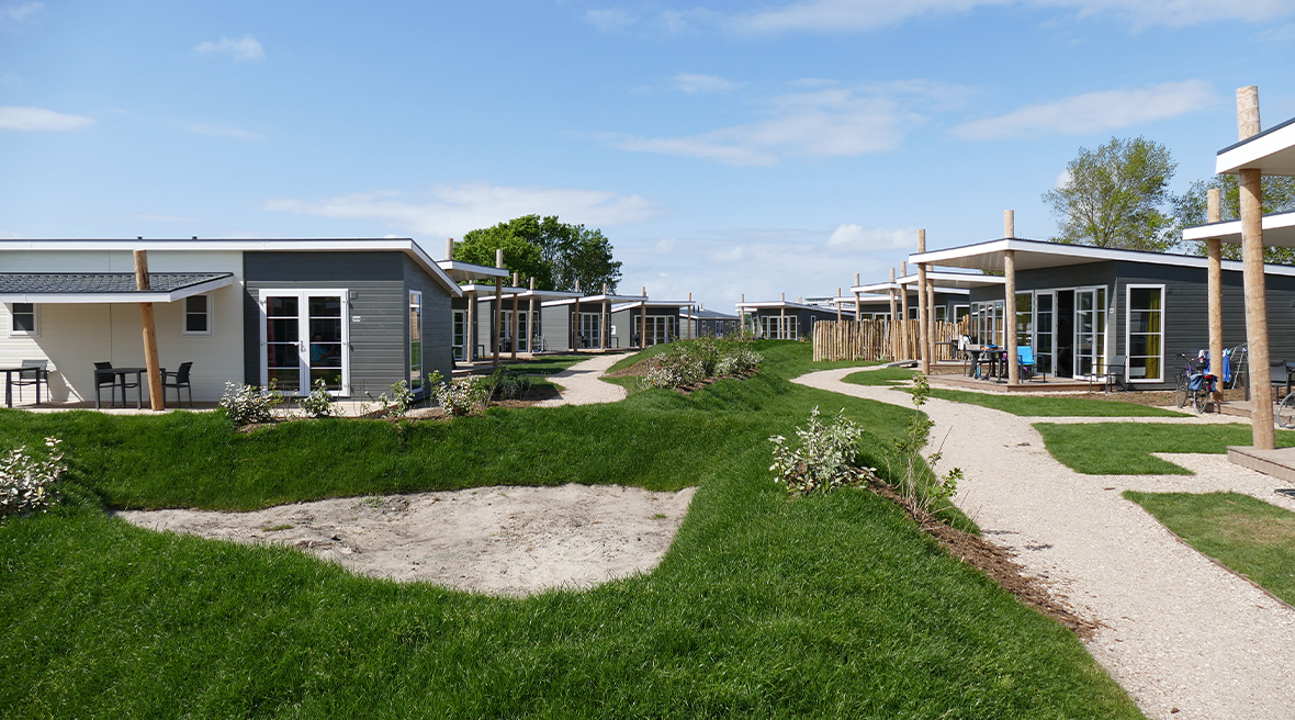 Cabins in rows, blue sky and bright green grass at Camping Nieuwpoort
